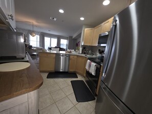 A modern kitchen with stainless steel appliances, wooden cabinets, and a central island. - Wonderful condo with cool AC, pool in charming Ship Bottom.Very spacious studio. (Ship Bottom)