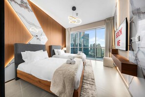 Ein modernes Hotelzimmer mit einem großen Bett, einem Schreibtisch und Blick auf die Stadt.