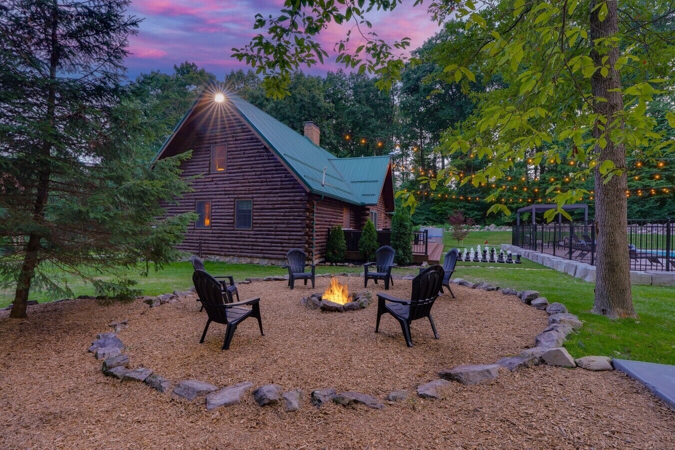 A log cabin with a fire pit and outdoor seating.