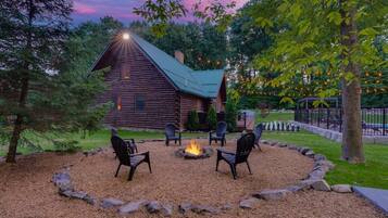A log cabin with a fire pit and outdoor seating.