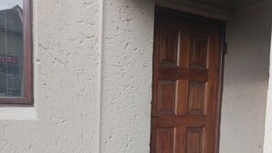 Una puerta con una pared texturizada y una ventana a la izquierda.