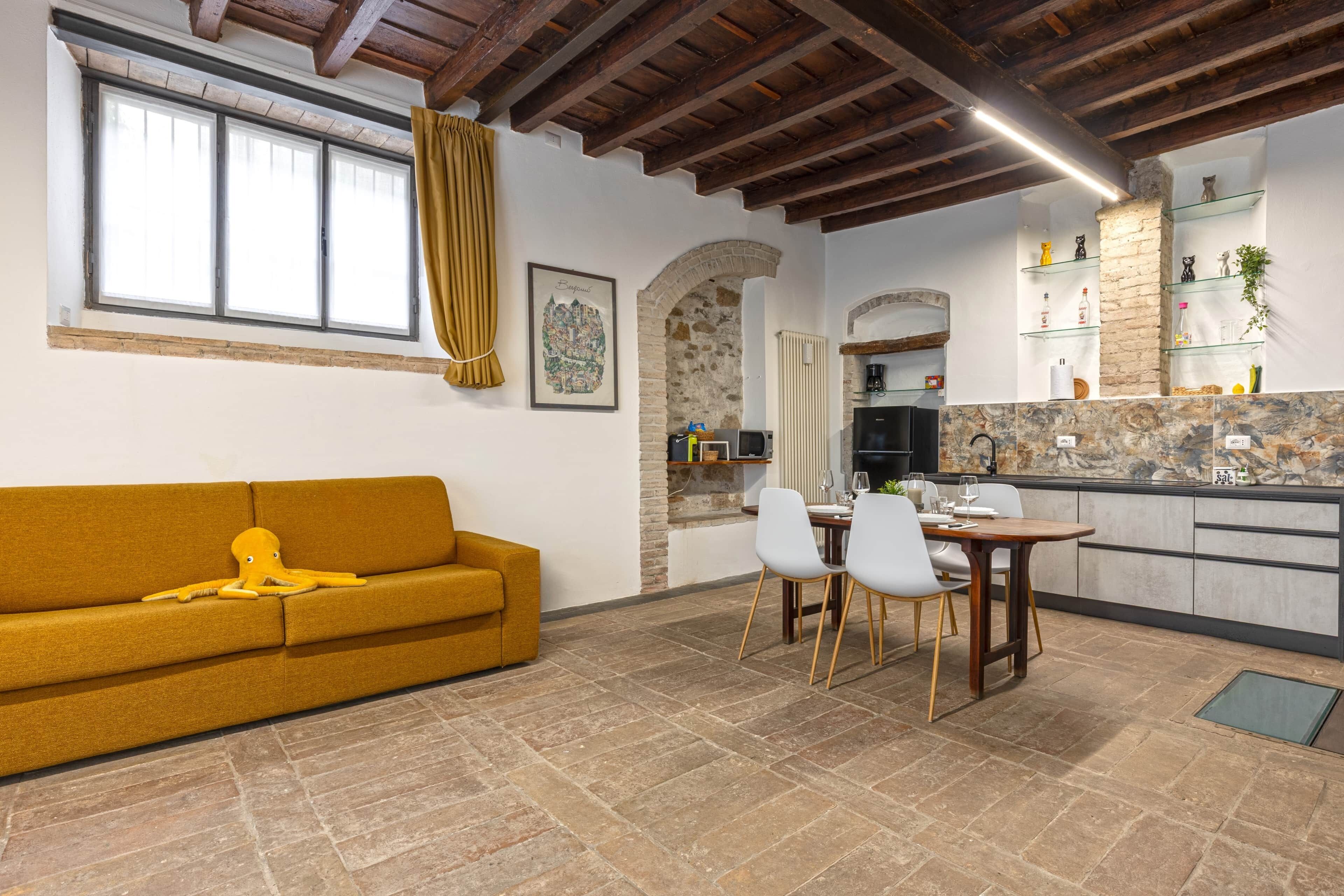 Un salon confortable avec un canapé et un coin repas comprenant des chaises et une table.