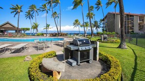 A pool area with lounge chairs, a barbecue grill, and palm trees. - Papakea | 2 Ocean View Villas, Sleeps 8 | Car Incl. w/ 6+ Nights | ML-4265 by KBM (Lahaina)