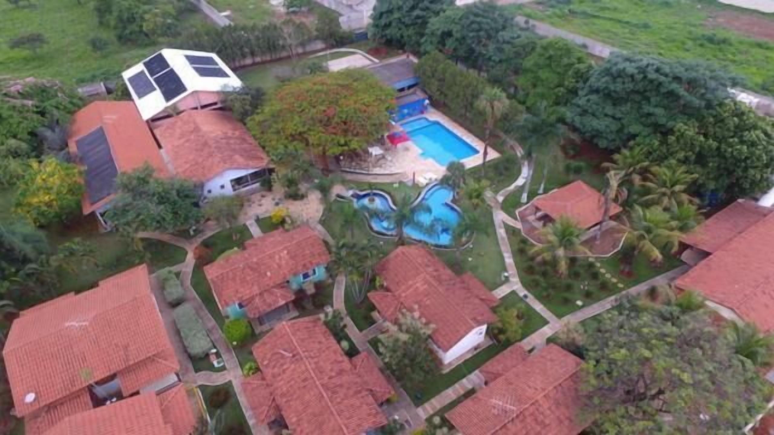 A residential area with multiple houses, a swimming pool, and a solar panel.