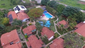 Un barrio residencial con varias casas, una piscina y un panel solar.