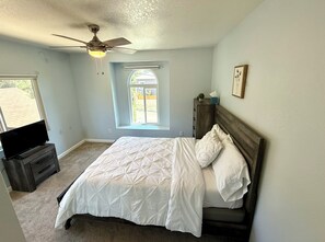 A bedroom with a bed, a ceiling fan, a window, a dresser, and a television. - 3 Bedroom Chatsworth Lake Manor Oasis (chatsworth)