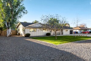 A single-story house with a front lawn, a driveway, and a garage. - Pickleball Ball Paradise (Phoenix)