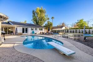 A swimming pool with a built-in slide, outdoor seating, and a covered patio area. - Pickleball Ball Paradise (Phoenix)