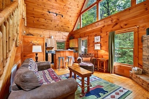 A log cabin interior with a living room, kitchen, and large windows. - Moonshine Romance Wood Cabin Retreat (Sevierville)