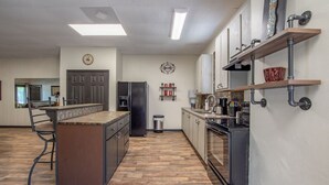 Een moderne keuken met een centraal eiland, inbouwapparatuur en een houten vloer.