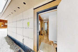 A hotel entrance with a wooden interior, a visible door, and a wall with numbered lockers. - Container-home Cottage Near Alyeska & Double Musky (Girdwood)