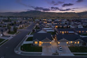 A suburban neighborhood with single-family homes, a main road, and a mountain range in the background.