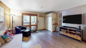 Ein Wohnzimmer mit einer Couch, einem Fernseher und einem Bücherregal.