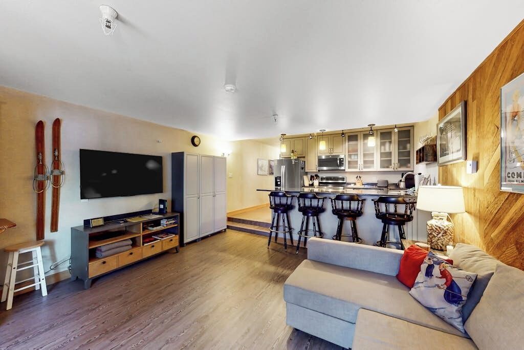 A modern living room with a flat-screen TV, a sofa, and a coffee table.