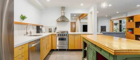 A modern kitchen with stainless steel appliances, wooden cabinets, and a central island.