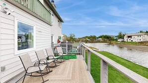 A waterfront property with a deck, rocking chairs, and a view of the river. - Elegant Anchorage Lakehouse w/ Direct Water Access (Anchorage)