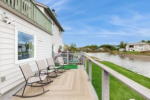 Ein Ufergrundstück mit Terrasse, Schaukelstühlen und Blick auf den Fluss.