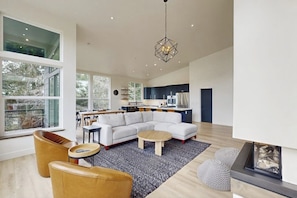 A modern living room with a sectional sofa, a coffee table, and a fireplace.