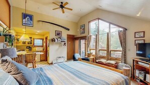 A bedroom with a large bed, a television, and a view of the outdoors. - Glacier-view Studio w/ Its Own Private Entrance (Girdwood)