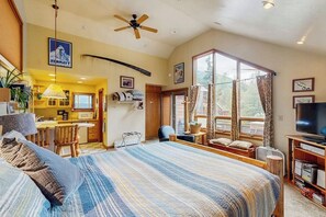 Un dormitorio con una cama grande, televisión y vistas al exterior.