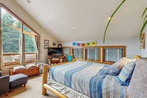 A bedroom with a large bed, a desk, and a view of the outdoors. - Glacier-view Studio w/ Its Own Private Entrance (Girdwood)