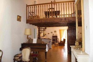 A spacious living area with a piano, a desk, and a comfortable seating arrangement. - Family villa with a pool and garden, featuring a view (Caumont-sur-Durance)