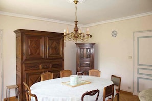 A dining room with a round table, wooden cabinets, and a chandelier. - Family villa with a pool and garden, featuring a view (Caumont-sur-Durance)