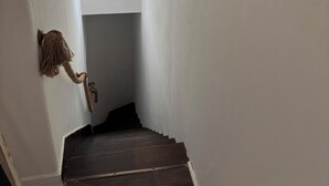 En smal hall med en trätrappa som leder upp till en liten plattform.