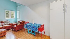 Una habitación con una mesa de comedor, sillas, un sofá y un armario.