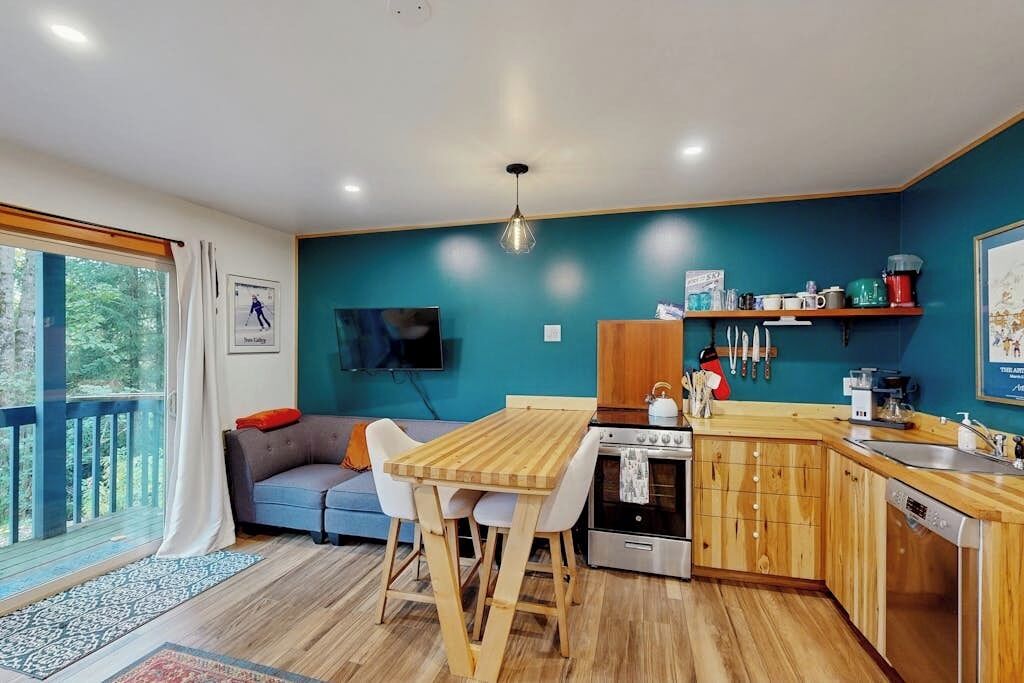A modern kitchen with wooden cabinets, a dining table, and a built-in oven.