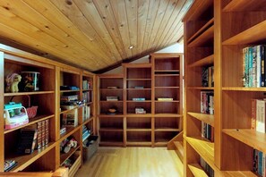 Eine Bibliothek mit Holzbögen und einer geneigten Decke.