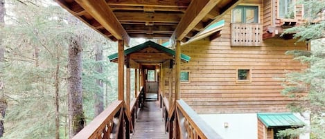Una cabaña de madera con un porche techado que lleva a la entrada.