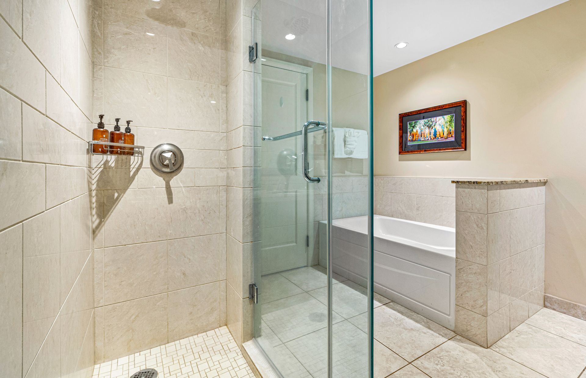 A bathroom with a glass shower enclosure, a bathtub, and a toilet.
