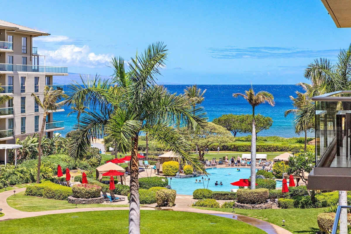 Ein Resort mit Schwimmbad, Palmen und Blick auf den Ozean.