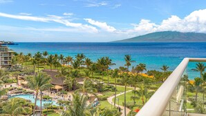 A resort with a pool, palm trees, and a view of the ocean. - Honua Kai Resort & Spa by Maui Resort Rentals (Kaanapali)