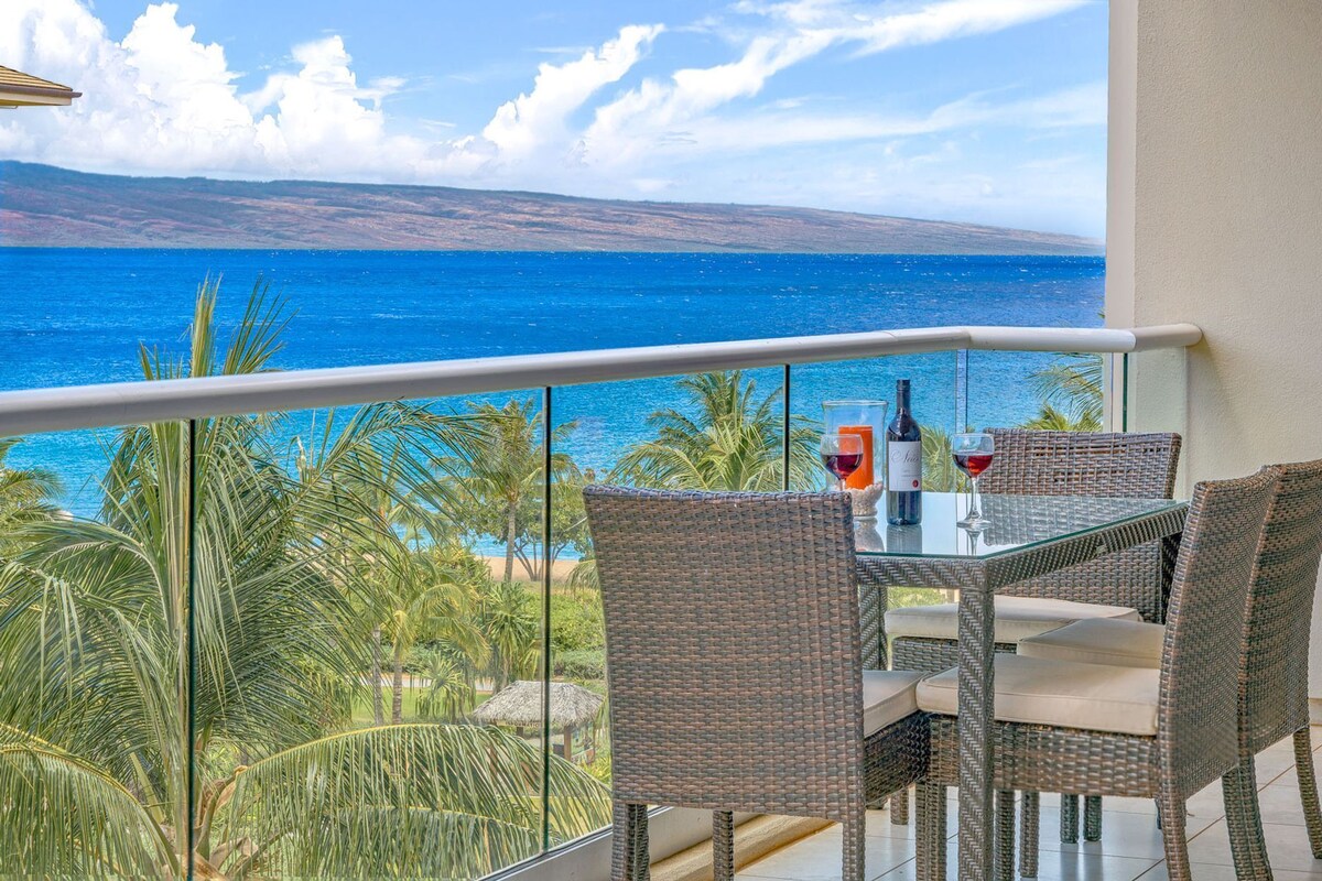Ein Balkon mit Korbmöbeln, einem Glastisch und einer Weinflasche.
