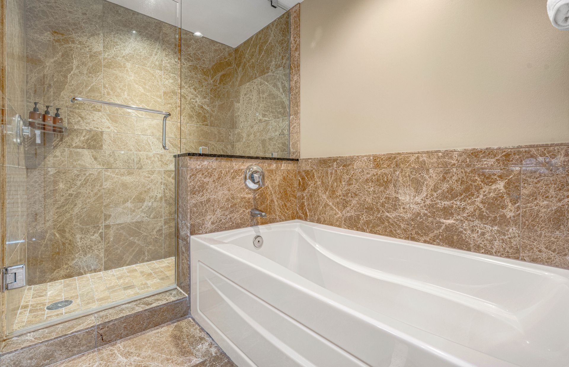 A bathroom with a shower, a bathtub, and a glass-enclosed shower area.