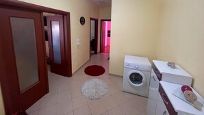 A laundry area with a washing machine, a dryer, and a countertop with a basket. - Modern apartment (Shkodër)
