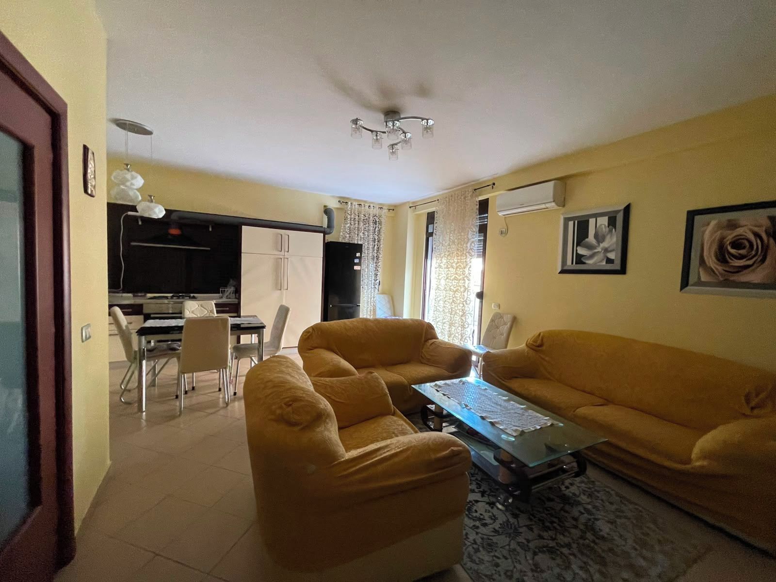 Una sala de estar con un sofá, una mesa de centro y un comedor con sillas y una mesa.