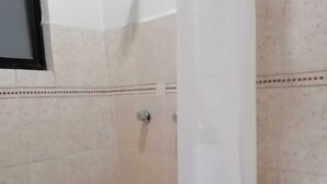 A bathroom with a shower, toilet, and a mirror. - Mayor's House (Oaxaca de Juárez)