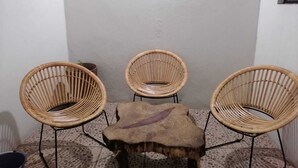 A corner with three wicker chairs and a small wooden table. - Mayor's House (Oaxaca de Juárez)