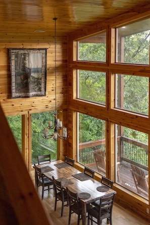A wooden interior with a dining table, chairs, and a chandelier. - High Smokies Lodge: Game Room, Hot Tub, Pet-Friendly (Sevierville)