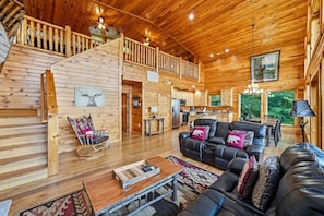 A spacious cabin with a wooden interior, a dining area, and a kitchen. - High Smokies Lodge: Game Room, Hot Tub, Pet-Friendly (Sevierville)