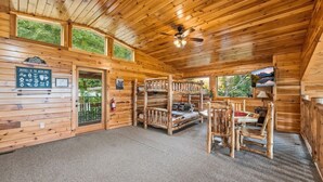 A cabin interior with a bunk bed, a fireplace, and a sign about local wildlife. - High Smokies Lodge - Game Room, Hot Tub and more! (Sevierville)