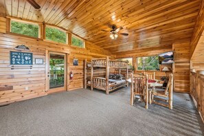 A cabin interior with a bunk bed, a fireplace, and a sign about local wildlife. - High Smokies Lodge - Game Room, Hot Tub and more! (Sevierville)