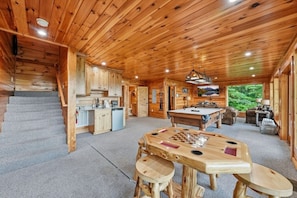 A wooden cabin interior with a kitchen, dining area, and a pool table. - High Smokies Lodge: Game Room, Hot Tub, Pet-Friendly (Sevierville)