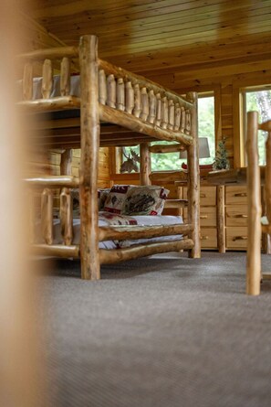 A bunk bed with a wooden frame and a mattress with a patterned cover. - High Smokies Lodge: Game Room, Hot Tub, Pet-Friendly (Sevierville)