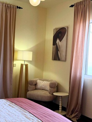 A hotel room with a bed, a chair, a small table, a lamp, and a painting on the wall. - Recanto da Bemposta by Stayguest (Machico)