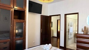 A hotel room with a bed, a television, a mirror, and a wardrobe. - Refúgio do Atalho by Stayguest (Santana)