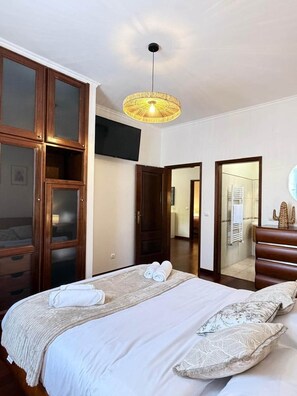 A hotel room with a bed, a television, a mirror, and a wardrobe. - Refúgio do Atalho by Stayguest (Santana)